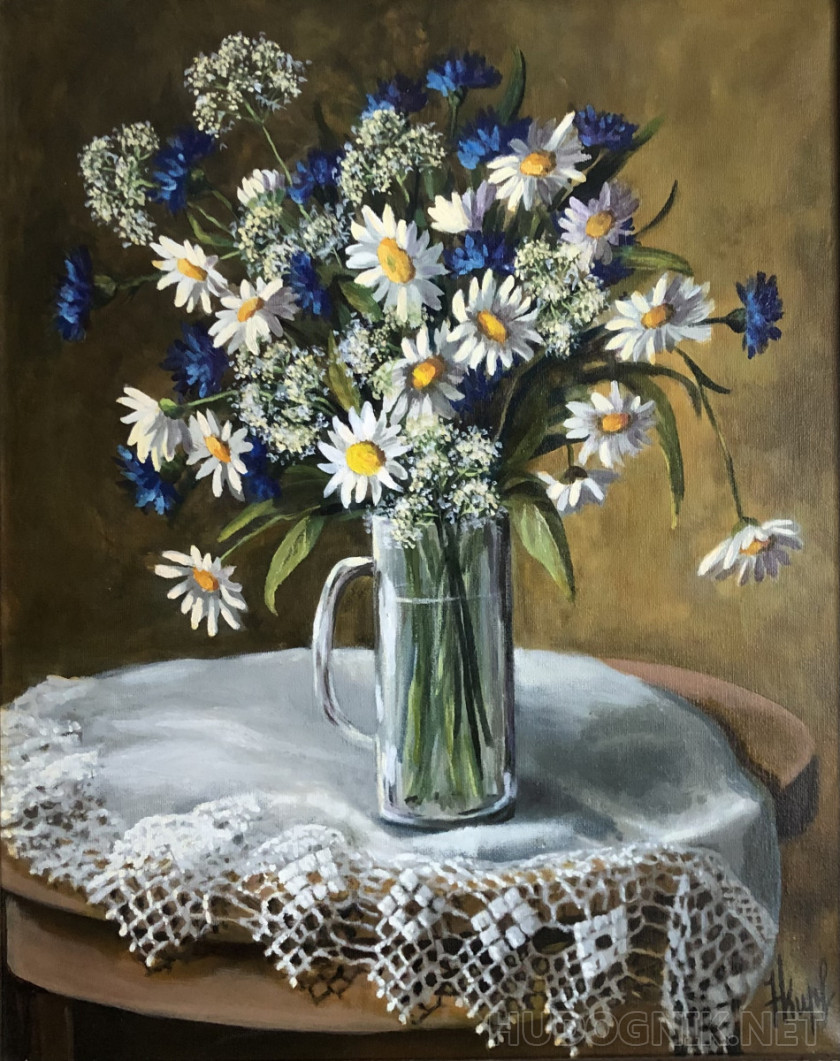 Daisies and cornflowers in a glass mug